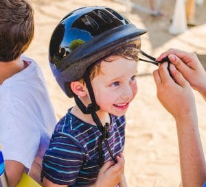 Camper getting help with his helmet