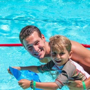 Camper swimming with counselor