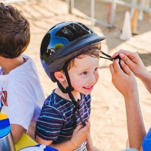 Camper getting help with his helmet