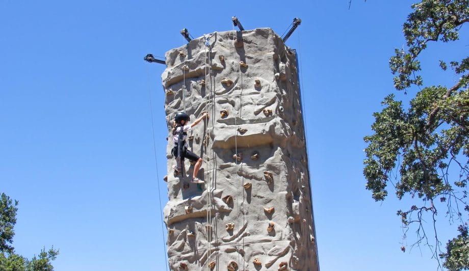 Camper climbing the rock climbing wall