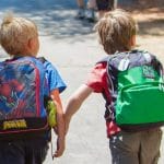 Two boys walk with backpacks