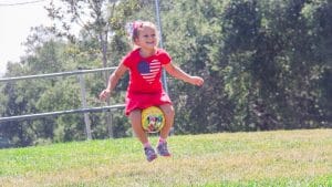 Camper jumping with a ball