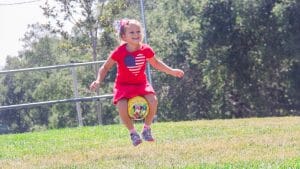 Camper jumping with a ball