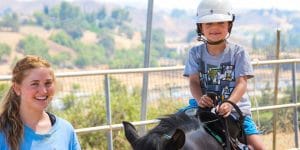 Camper riding a pony