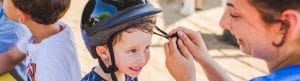 Staff helping camper with helmet