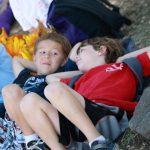 Two campers laying on the grass